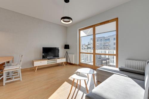 a living room with a couch and a tv at Holiday Apartment near the Sea - free private parking in Gdańsk
