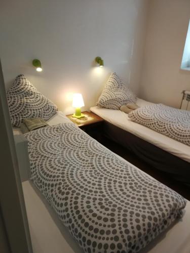 two beds in a room with a lamp on a table at Grenaa Bed and Breakfast in Grenå