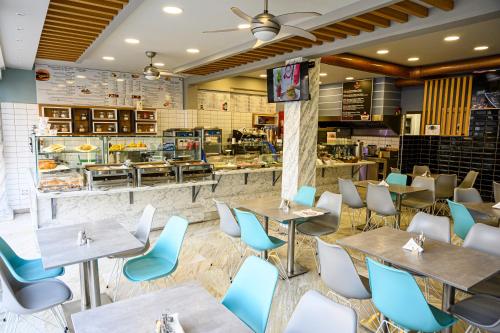 een restaurant met tafels en stoelen en een bakkerij bij Oxygen in Olympiakí Aktí