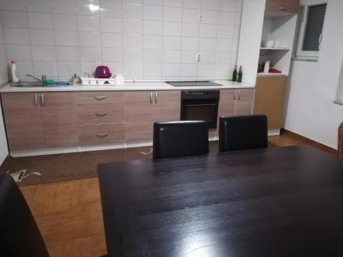 cocina con mesa, sillas y encimera en Apartman Jurak en Travnik