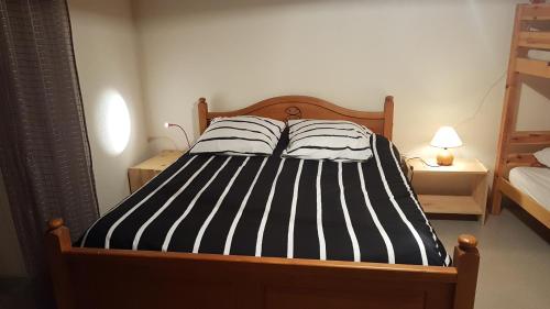 BramansにあるGites de la combeのベッドルーム1室(黒と白のストライプのベッド1台付)