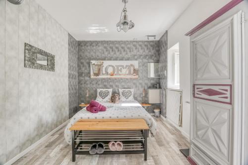 a bedroom with a bed with pink shoes on it at Jolysable in Pons