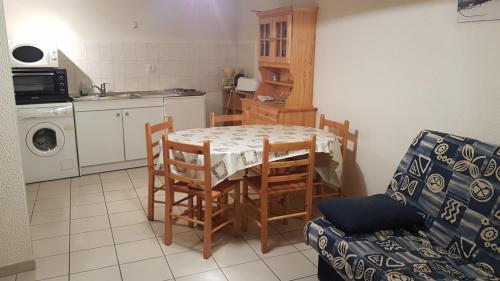 une cuisine avec une table et des chaises dans une pièce dans l'établissement Gites de la combe, à Bramans