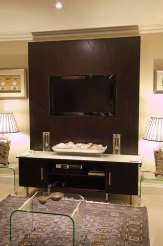 a living room with a flat screen tv on a wall at Forest Manor Boutique Guesthouse in Durban