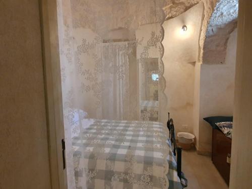 a bedroom with a bed with a checkered blanket at I Trulli di Nonna Maria in Alberobello