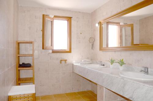 a white bathroom with two sinks and a window at B16-Dúplex luminoso+ piscina a 150 m del mar in Charco del Palo