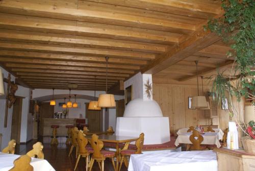 a dining room with wooden ceilings and a table and chairs at Gasthof Hirschen in Wenns