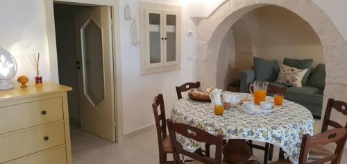 a dining room with a table and a couch at I Trulli di Nonna Maria in Alberobello