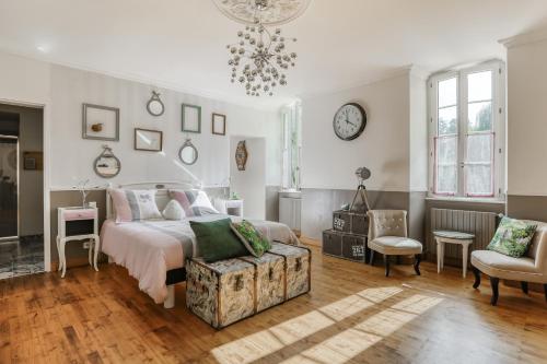 a bedroom with a bed and a chair and a chandelier at Jolysable in Pons