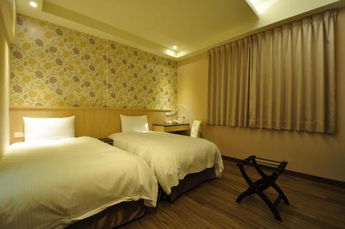 a hotel room with two beds and a window at Fupin Hotel in Hualien City
