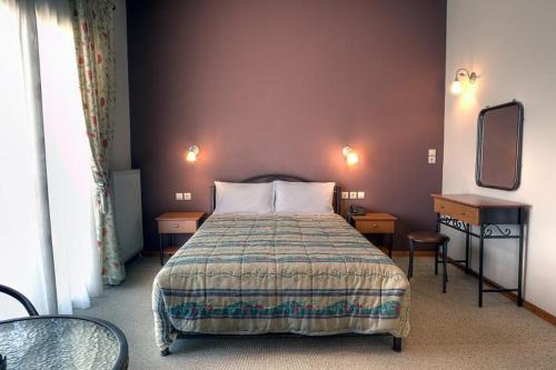 1 dormitorio con cama, mesa y espejo en Guesthouse Evi Maria en Ángistron