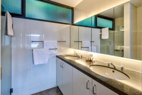 a bathroom with a sink and a mirror at Waves 5 Luxury 3 Bedroom Breathtaking Ocean Views Central Location in Hamilton Island