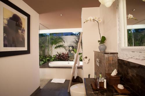Kejora Suites في سانور: حمام مع حوض ومرحاض ومغسلة