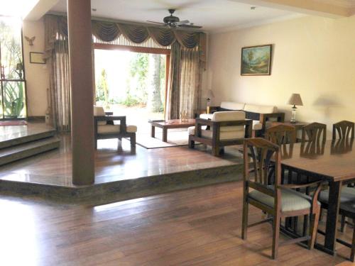 a living room with wooden floors and a table and chairs at Silvikris Villa in Colombo