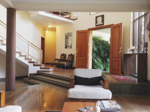 a living room with a chair and a staircase at Silvikris Villa in Colombo