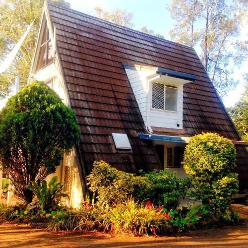 a house with a gambrel roof with a window at Family or Friends Cottage in North Tamborine