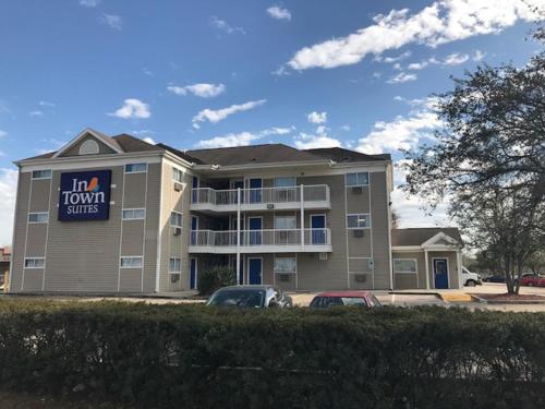 a large apartment building with cars parked in a parking lot at InTown Suites Extended Stay Houston TX - Hwy 290 Cypress Fairbanks in Houston