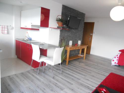eine Küche mit roten Schränken sowie einem Tisch und Stühlen in der Unterkunft Central Studio with Lake View | 102 in Montreux