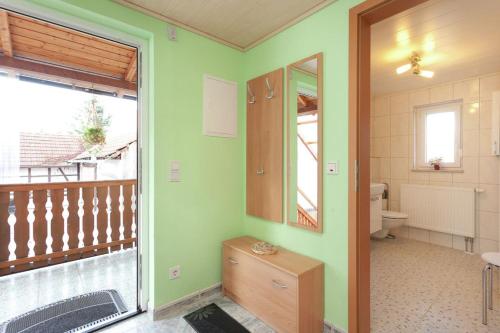 a green bathroom with a toilet and a balcony at Drachenstein in Wutha-Farnroda