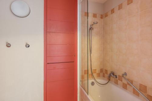 y baño con ducha y puerta roja. en Residences Quartier Falaise - maeva Home en Avoriaz