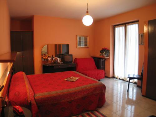 una camera con un letto rosso e una sedia rossa di Hotel La Lanterna a Chiesa in Valmalenco