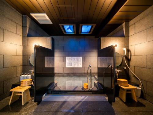 a bathroom with two sinks and a tub with a shower at Super Hotel Premier Akihabara in Tokyo