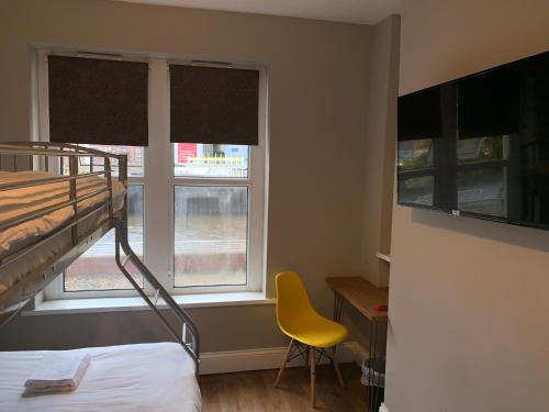 a bedroom with a bunk bed and two windows at The Riverhouse in Cardiff