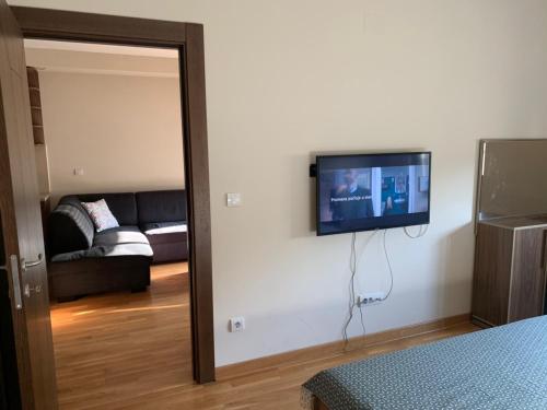 ein Wohnzimmer mit einem Flachbild-TV an der Wand in der Unterkunft BELLA APARTMENT in Belgrad