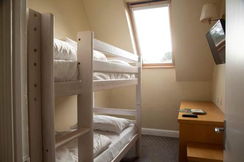 a room with three bunk beds with white towels at The Murray Park Hotel in Crieff