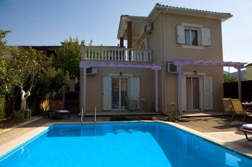 a villa with a swimming pool in front of a house at Le Torri Villas by Nidri holiday villas in Nydri