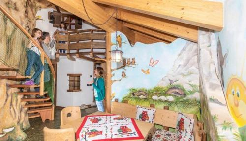 a room with a mountain mural on the wall at MyTime Hotels la Grotta in Vigo di Fassa