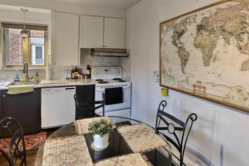 a kitchen with a table and a map on the wall at Gite du Survenant Montreal in Montréal