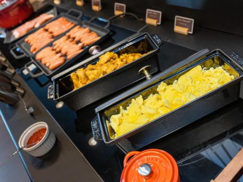 a buffet line with hot dogs and other food at Super Hotel Premier Akihabara in Tokyo
