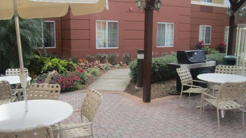 an outdoor patio with tables and chairs and a grill at Extended Stay America Suites - Orlando - Convention Center - Universal Blvd in Orlando