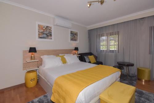 a bedroom with a large bed with a yellow blanket at Douro Prime Downtown in Vila Nova de Gaia