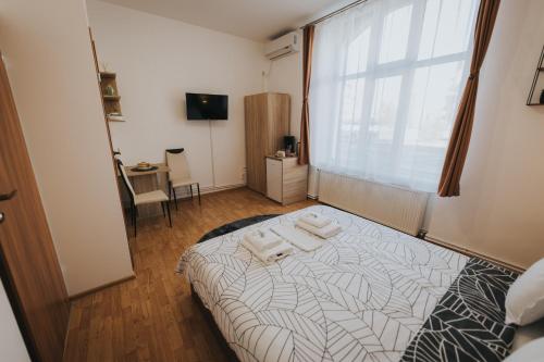 1 dormitorio con 1 cama con toallas en Gavri's Classic Apartment, en Sibiu