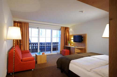 una camera d'albergo con un letto, una sedia e una finestra di Hotel Saalbacher Hof a Saalbach Hinterglemm