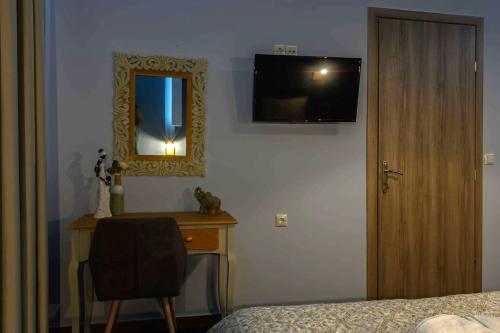 a bedroom with a mirror and a desk with a chair at Central Rooms in Kalamata