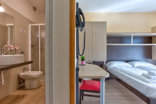 a hotel room with a bed and a sink at Hotel Roma in Nago-Torbole