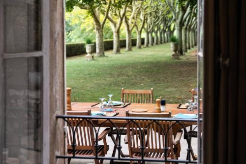 une table et des chaises assises sur une terrasse dans l'établissement La Féraude - Pays d'Aix en Provence, à Gardanne