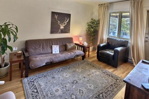 a living room with a leather couch and a chair at Gite du Survenant Montreal in Montréal