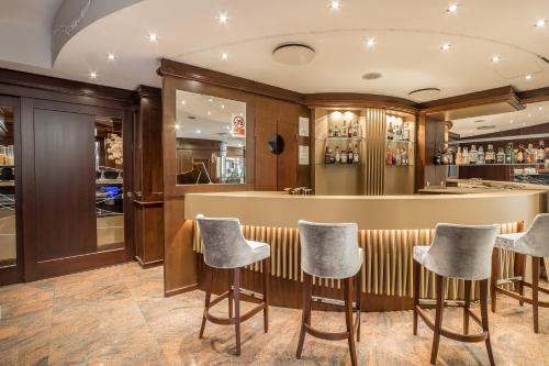 a bar in a restaurant with stools at Hotel Mythos in Milan