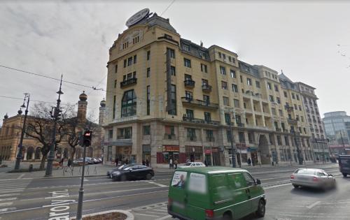 a green van driving down a street in front of a building at Maria Boutique Suits in Budapest