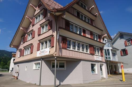 un grande edificio di colore marrone e bianco di Zwinglis Ferienwohnung Klärli a Nesslau
