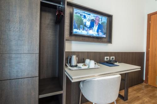 a room with a desk and a tv on a wall at Hotel Mythos in Milan