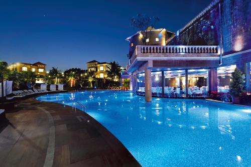 una gran piscina en un hotel por la noche en Della Resorts, en Lonavala