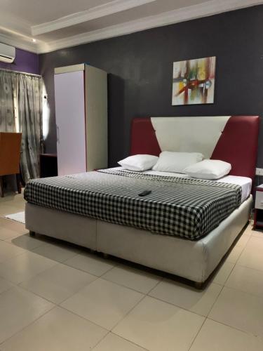 ein Schlafzimmer mit einem großen Bett in einem Zimmer in der Unterkunft Pulville Boulevard in Lagos