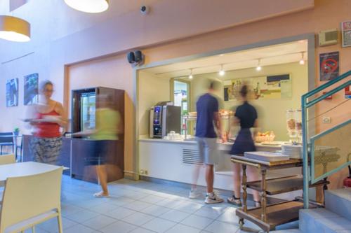 a group of people standing in a fast food restaurant at Résidence Villemanzy in Lyon