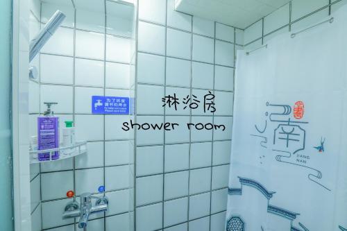 a bathroom with a shower room with writing on the wall at 弱水咖啡国际青旅 Only Cafe and Backpacker in Chongqing
