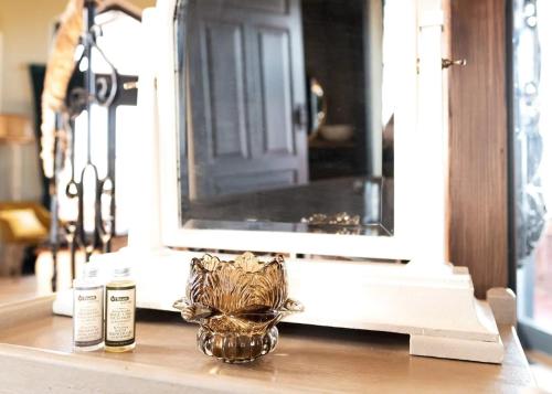 a glass vase sitting on a table in front of a mirror at amberner Penthouse in Bad Waltersdorf